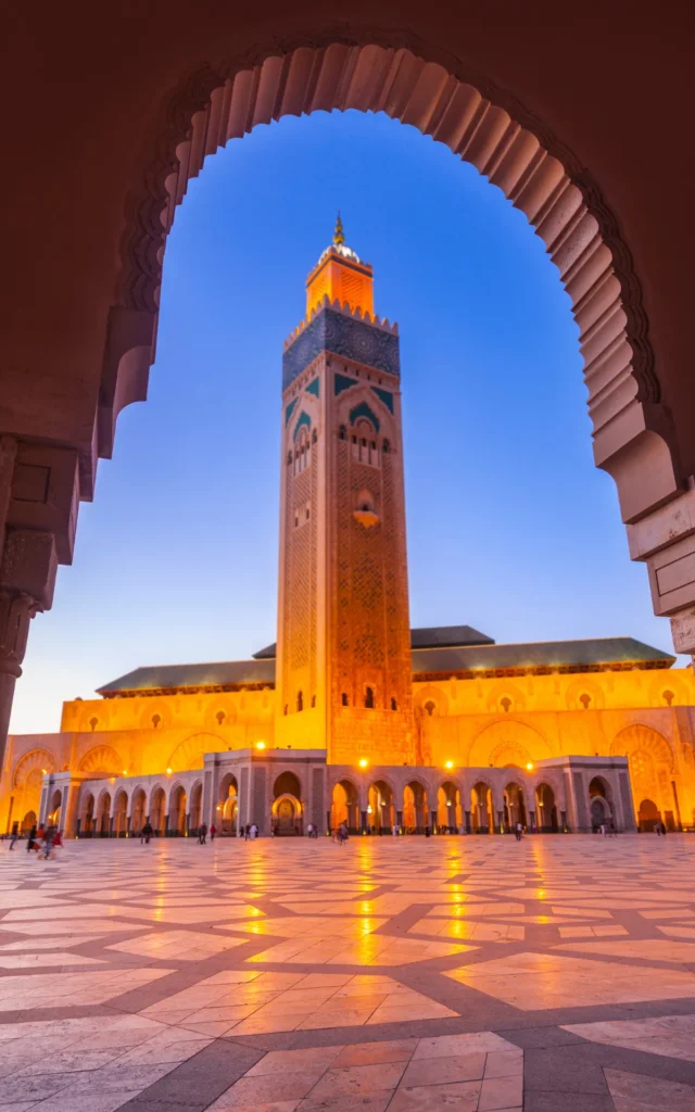 Hassan II Mosque in Casablanca at sunset framed by a traditional arch